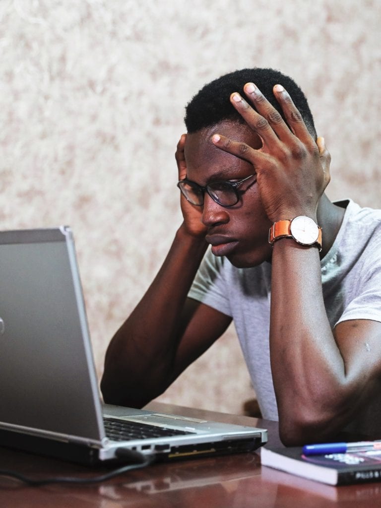 Stressed young man at a computer.